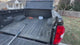 Magnetic truck bed hook grabber attached to extension pole in pickup truck bed